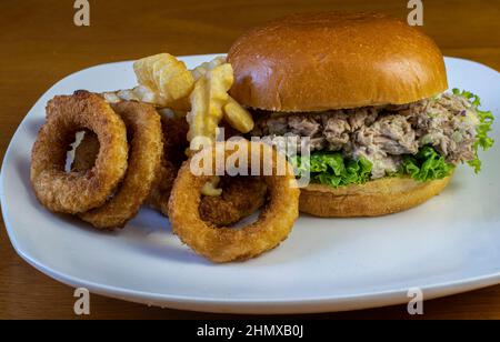 salade de thon sur un pain brioche et servi avec des frites et des rondelles d'oignon Banque D'Images