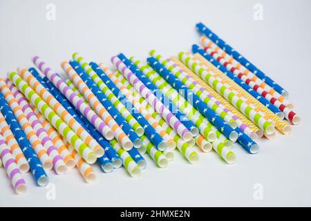 Pailles en papier spiralées ou rayées colorées isolées sur fond blanc, y compris le chemin d'écrêtage. Banque D'Images