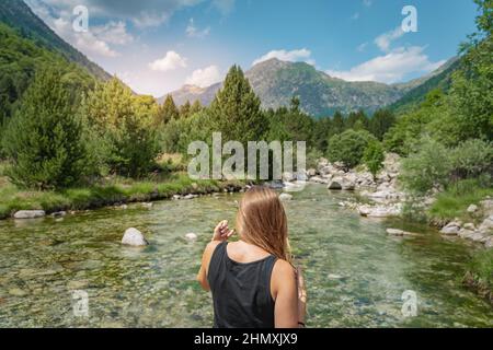 Jeune femme randonnée dans une belle rivière entre les montagnes pendant le coucher du soleil. Concept de destination de voyage Discovery Banque D'Images