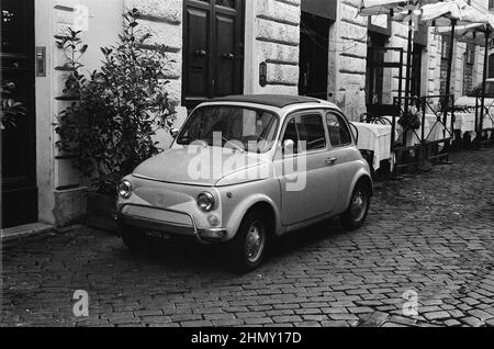 Photo en noir et blanc d'une voiture italienne classique, typique Fiat 500 dans la rue Banque D'Images