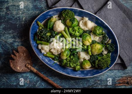 Vue de haut en bas d'un plat rempli de légumes crucifères et de légumes verts cuits à la vapeur. Banque D'Images