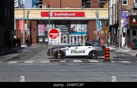 Toronto, Canada. 12th févr. 2022. Une voiture de police bloque une rue pour empêcher les véhicules protestataires de s'y rendre avec un panneau indiquant que la route est fermée à Toronto, Canada, le 12 février 2022. Des manifestants se sont rassemblés ici samedi pour une autre série de manifestations en solidarité avec les manifestations de convoi de camions à Ottawa. La manifestation du « Freedom Convoy 2022 » a commencé le 29 janvier, à l'initiative d'un rassemblement de camionneurs contre l'exigence selon laquelle les camionneurs canadiens qui franchissent la frontière avec les États-Unis doivent être entièrement vaccinés à la mi-janvier. Credit: Zou Zheng/Xinhua/Alamy Live News Banque D'Images