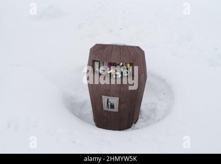 NORBOTTEN, SUÈDE - 24 FÉVRIER 2020 : bac à poussière plein avec des canettes de bière vides dans la neige profonde Banque D'Images