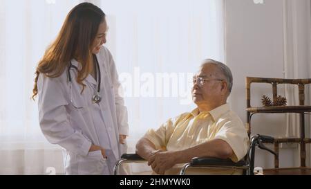 Infirmière femme médecin porter un uniforme blanc embrassant encourageant heureux du patient aîné ou âgé vieil homme pendant assis sur un fauteuil roulant encourager et empathie Banque D'Images