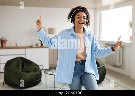 Femme noire écoutant de la musique et dansant à la maison Banque D'Images