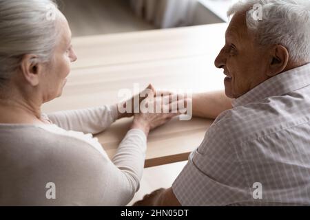 Femme aux cheveux gris et aux personnes âgées soignées, apportant du réconfort au vieux mari Banque D'Images