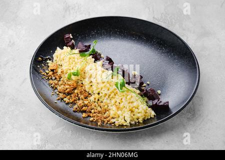 Garnissez le plat principal - orge perlé bouilli, betterave frite et chapelure sur une assiette Banque D'Images