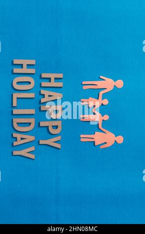 Coupe de papier des familles heureuses tenant les mains ensemble isolées sur fond bleu. Résumé Joyeux thème de vacances. Verticale Banque D'Images