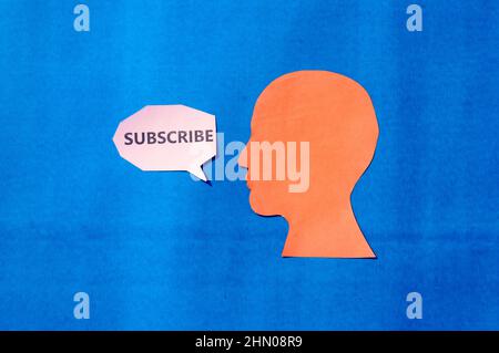 Papier visage humain avec abonnement mot sur bulle de parole isolée sur fond bleu. Copier l'espace pour le texte. Banque D'Images