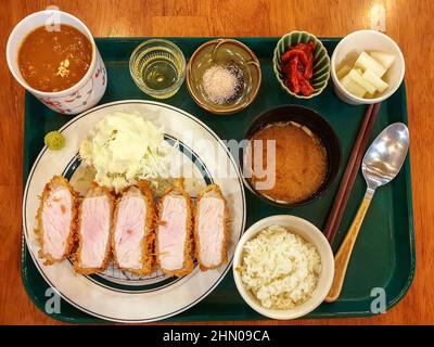 Tonkatsu, côtelette de porc panée et frite au Japon. Servi avec une salade de chou, du wasabi, du sel himalayan, de l'huile de truffe, de la soupe miso, curry et riz. Banque D'Images