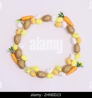 Espace de copie de cadre créatif sur fond blanc avec œufs et carottes pour Pâques. Concept de pose à plat Banque D'Images