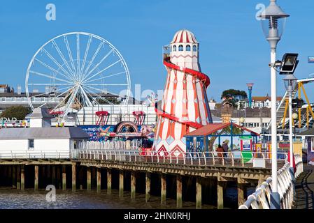 Clacton Pier Funfair avec une grande roue et un squelette d'helter entre autres manèges. Banque D'Images