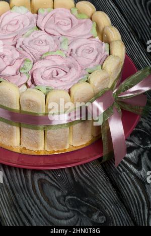 Gâteau avec biscuits Savoiardi et roses guimauves. Attaché avec ruban. Le ruban est attaché dans un noeud. Banque D'Images