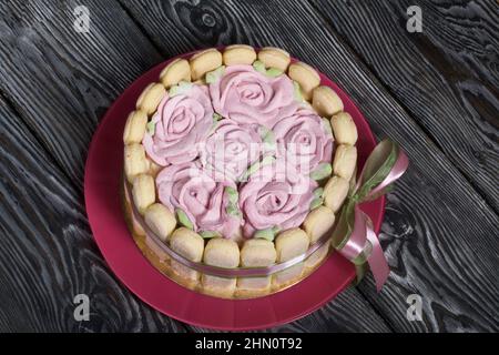 Gâteau avec biscuits Savoiardi et roses guimauves. Attaché avec ruban. Le ruban est attaché dans un noeud. Banque D'Images