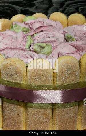 Gâteau avec biscuits Savoiardi et roses guimauves. Attaché avec ruban. Le ruban est attaché dans un noeud. Banque D'Images