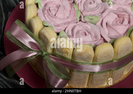 Gâteau avec biscuits Savoiardi et roses guimauves. Attaché avec ruban. Le ruban est attaché dans un noeud. Banque D'Images