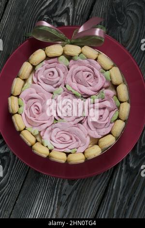 Gâteau avec biscuits Savoiardi et roses guimauves. Attaché avec ruban. Le ruban est attaché dans un noeud. Banque D'Images