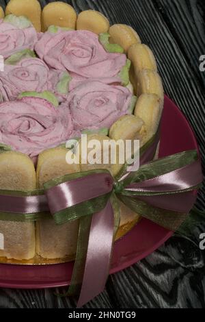 Gâteau avec biscuits Savoiardi et roses guimauves. Attaché avec ruban. Le ruban est attaché dans un noeud. Banque D'Images