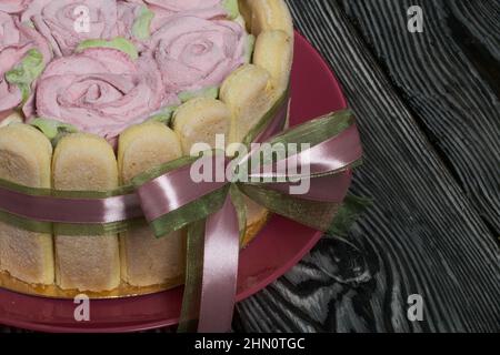 Gâteau avec biscuits Savoiardi et roses guimauves. Attaché avec ruban. Le ruban est attaché dans un noeud. Banque D'Images