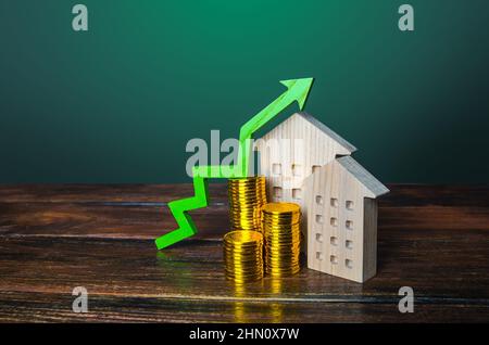 Flèche verte vers le haut sur les maisons en bois. Augmentation du coût du concept de logement. Forte demande de biens immobiliers. Croissance des taux hypothécaires. Vente appartements. Prix i Banque D'Images