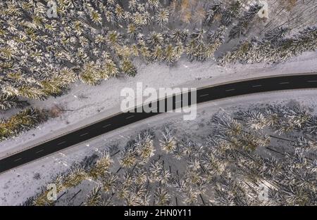 Vue de dessus de la forêt d'hiver et de la route au coucher du soleil Banque D'Images