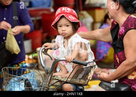 Une jeune fille vietnamienne s'assoit sur un vélo dans le marché de la nourriture du matin animé à Cai Rang, près de CAN Tho, le delta du Mékong, le sud du Vietnam Banque D'Images