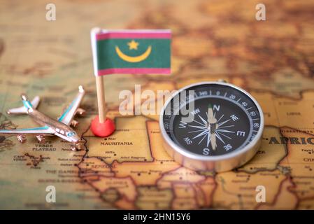Drapeau de la Mauritanie, boussole et avion sur la carte du monde. Le concept de voyage et de tourisme. Banque D'Images