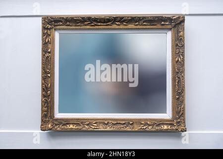 Exposition de galerie d'art, cadre de peinture sur un mur blanc. Antique doré orné, motif floral, espace de copie Banque D'Images