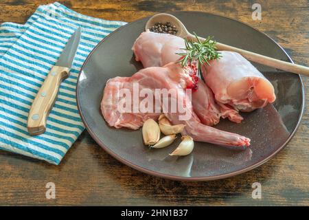 lapin cru dans une plaque sur une table en bois Banque D'Images
