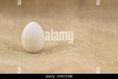 Œuf en bois sur fond de toile de fond naturelle. Œufs de Pâques en bois. Œuf sur la toile à neige. Copier l'espace pour le texte. Banque D'Images