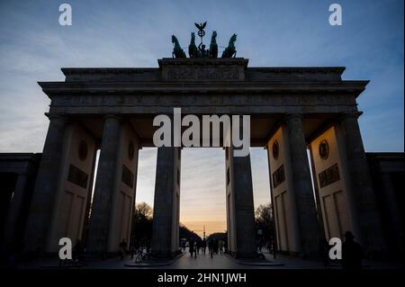 Berlin, Allemagne. 13th févr. 2022. Le soleil se couche derrière la porte de Brandebourg. Credit: Christophe bateau/dpa/Alay Live News Banque D'Images