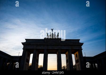 Berlin, Allemagne. 13th févr. 2022. Le soleil se couche derrière la porte de Brandebourg. Credit: Christophe bateau/dpa/Alay Live News Banque D'Images