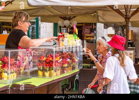 VÉRONE, ITALIE - 19th juillet 2019 : une femme mûre achète des ensembles de fruits dans la rue de Vérone Banque D'Images