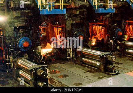 Une vue à la mi-1980s à l'intérieur des aciéries de Port Talbot, une usine intégrée de production d'acier à Port Talbot, West Glamourgan, pays de Galles, Royaume-Uni. À l'intérieur du moulin, des tôles d'acier chaudes sont déployées sur la chaîne de production. Cette image est tirée d'une transparence de couleur vintage – une photographie vintage 1980s. Banque D'Images