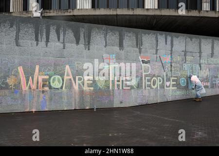 Les manifestants s'appuient sur un mur à l'occasion de la manifestation sur le mandat du vaccin contre les covidés devant le Parlement à Wellington, en Nouvelle-Zélande, le 13 février 2022 Banque D'Images