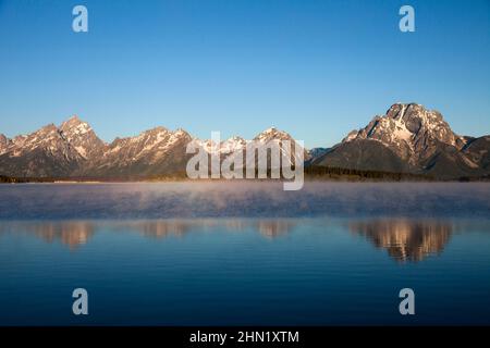 Brume matinale sur Jackson Lake, avec la chaîne de Grand Teton en arrière-plan, mai, Grand Teton NP, Wyoming, États-Unis Banque D'Images