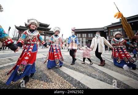 Danzhai, province chinoise du Guizhou. 13th févr. 2022. Les touristes dansent avec les gens du groupe ethnique Miao à Wanda ville du comté de Danzhai à Qiandongnan Miao et préfecture autonome de Dong, province de Guizhou, dans le sud-ouest de la Chine, le 13 février 2022. Divers événements ont lieu dans toute la Chine pour célébrer le prochain festival Lantern. Credit: Huang Xiaohai/Xinhua/Alamy Live News Banque D'Images