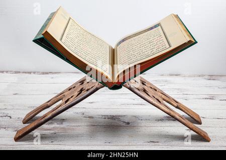 Istanbul, Turquie - 11 février 2022 ; Saint Coran et prière sur stand. Ouvert aux prières du Coran, aux prières musulmanes sur parquet dans la mosquée, dos sombre Banque D'Images