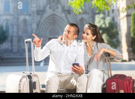Deux voyageurs se reposant sur un banc, regardant les sites touristiques Banque D'Images