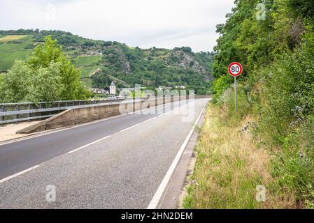 Route déserte longeant une rivière au fond d'une vallée par une journée d'été nuageux Banque D'Images