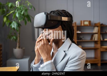 J'ai impressionné une femme d'affaires afro-américaine qui se sentait excitée lors des tests de micro-casque vr au bureau Banque D'Images