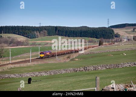 DB CARGO / EWS classe 66 diesel locomotive66200 dans la campagne de Cumbrian sur la ligne principale électrifiée de la côte ouest avec train de fret. Banque D'Images