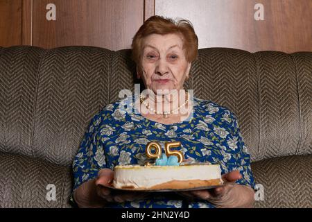 femme de quatre-vingt-quinze ans avec une bonne présence, avec son gâteau d'anniversaire. Banque D'Images