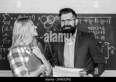 Jeune enseignant près du tableau noir dans la salle de classe de l'école. Concept de connaissances de l'éducation des étudiants sur le campus. Concept de collaboration d'équipe. Journée des enseignants. Jour d'école. Banque D'Images