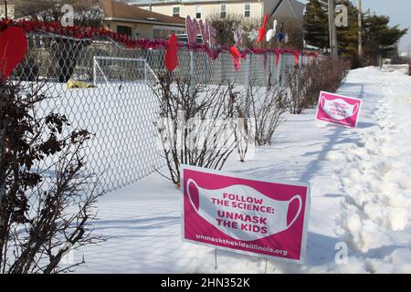 Suivez les panneaux Science Unmask the Kids Lawn avec Valentines Hearts dans la neige à Morton Grove, Illinois Banque D'Images