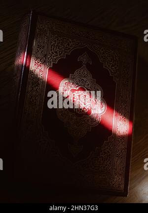 Couverture du saint livre arabe musulman Quran avec rayon droit de lumière du soleil, priez le temps du ramadan Banque D'Images