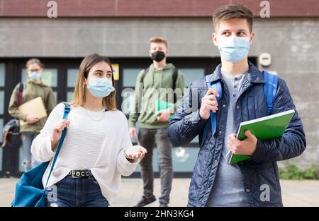 Adolescents dans les masques marchant après les leçons Banque D'Images