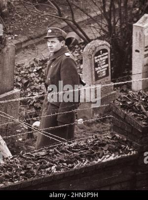 Photo d'époque de la crise de Berlin de 1961 : construction du poste de police populaire du mur au cimetière de Bernauer Strasse. Berlin, octobre 1961 Banque D'Images