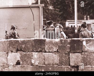Photo vintage de la crise de Berlin de 1961: Construire le mur allemand de l'est troupes et le groupe de police ensemble derrière le mur construit par les communistes pour sceller Banque D'Images