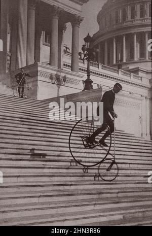 La photographie d'époque montre un homme à vélo sur les marches du Capitole des États-Unis tandis qu'un autre homme avec un vélo attend au sommet. 1884 Banque D'Images